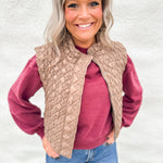 Woman wearing a light brown quilted vest with zipper front over a washed cherry color crewneck sweatshirt from Thread & Supply