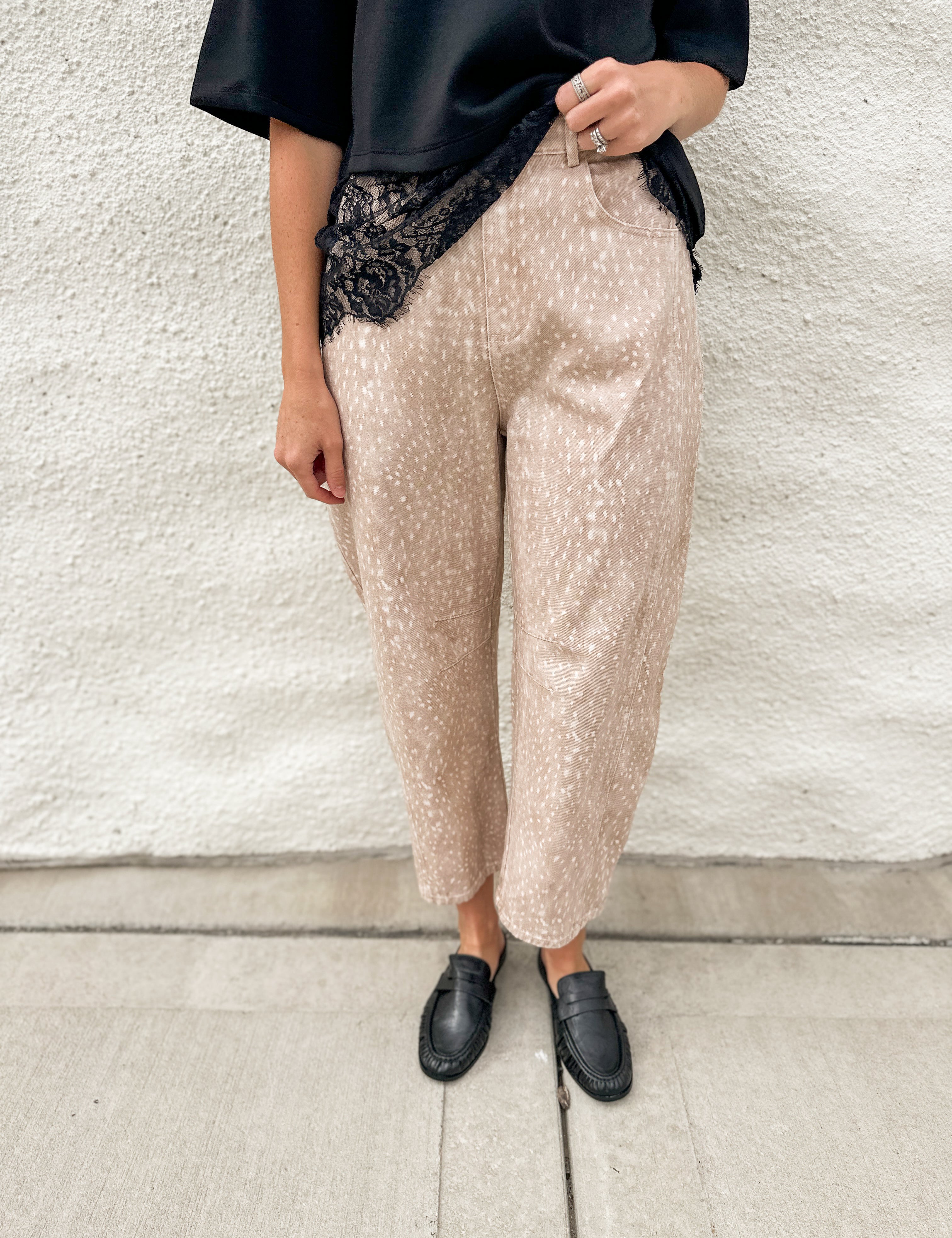 Woman wearing scuba black tee with lace hem detail and fawn printed barrel denim jeans with black loafer mules