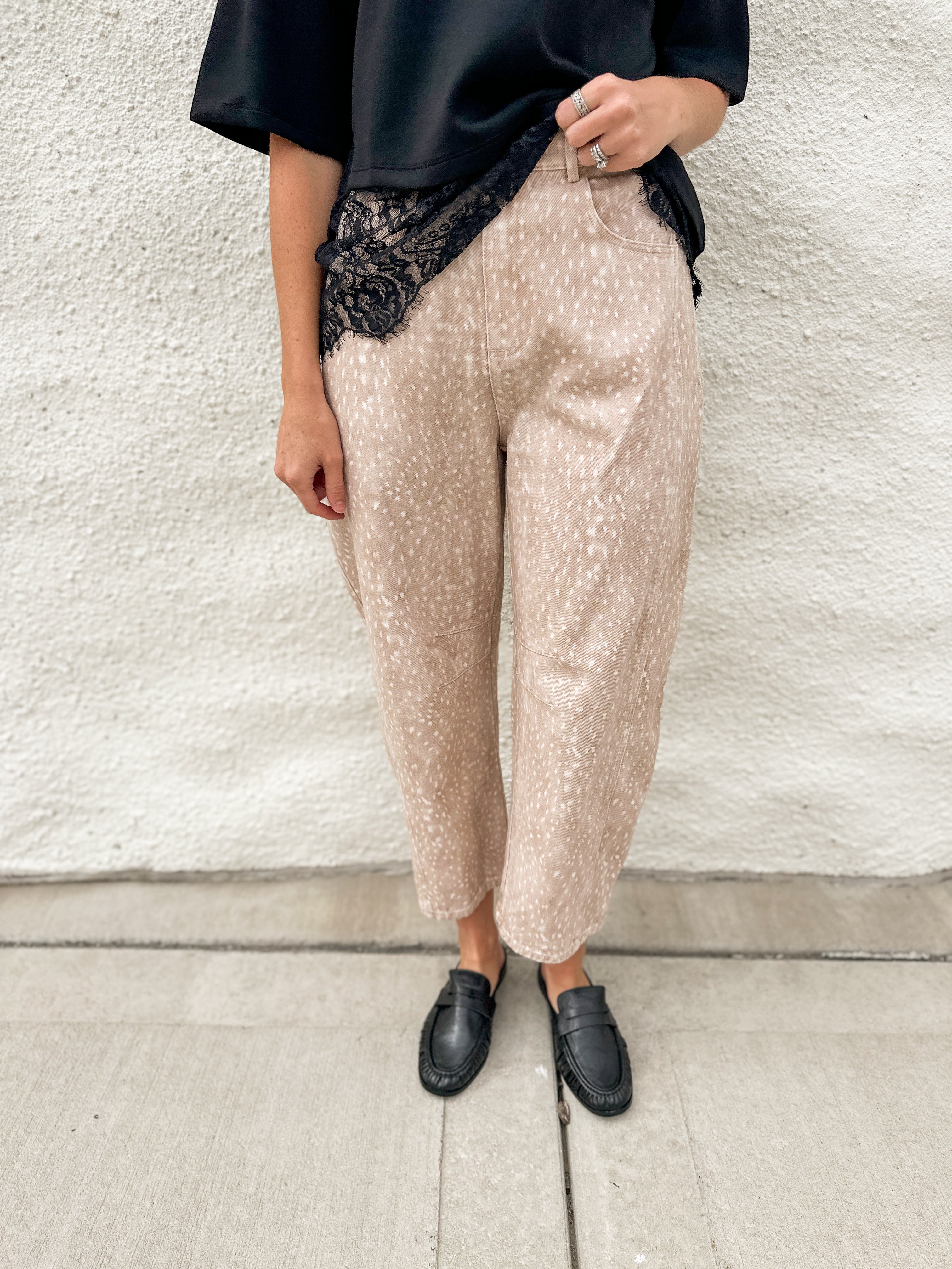 Woman wearing scuba black tee with lace hem detail and fawn printed barrel denim jeans with black loafer mules