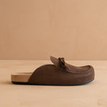 Brown leather loafer on a beige background