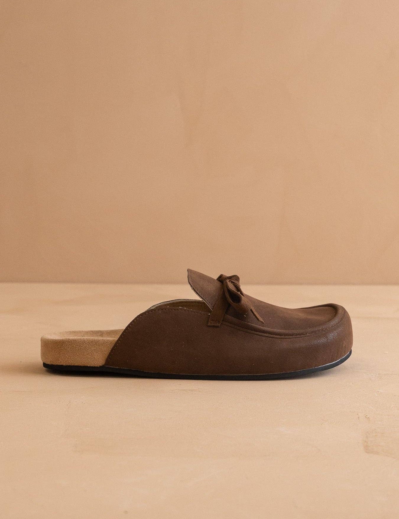 Brown leather loafer on a beige background