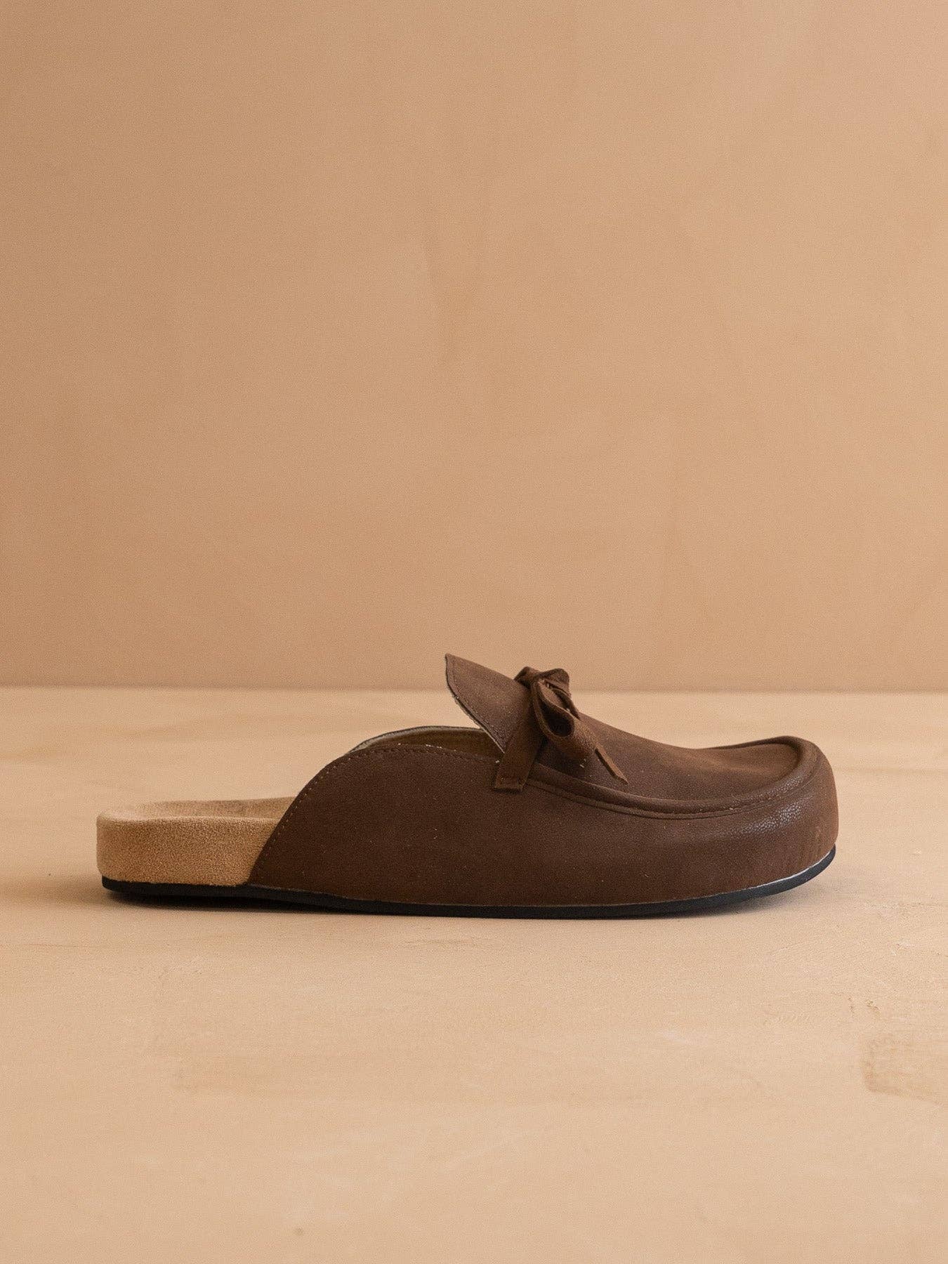 Brown leather loafer on a beige background