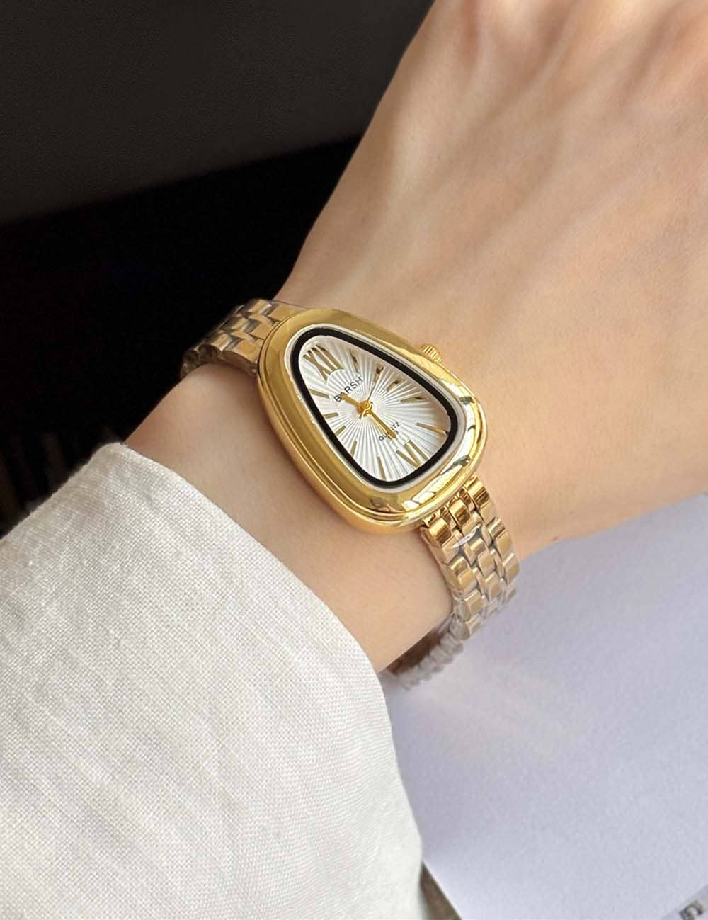 Gold watch with classic watchband chain, geometric oval clock shape with white mother of pearl look face and gold dial, black outline around white face, sleek gold faceplate