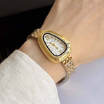 Gold watch with classic watchband chain, geometric oval clock shape with white mother of pearl look face and gold dial, black outline around white face, sleek gold faceplate