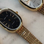 Gold watch with oval frame, mesh wristband and black face