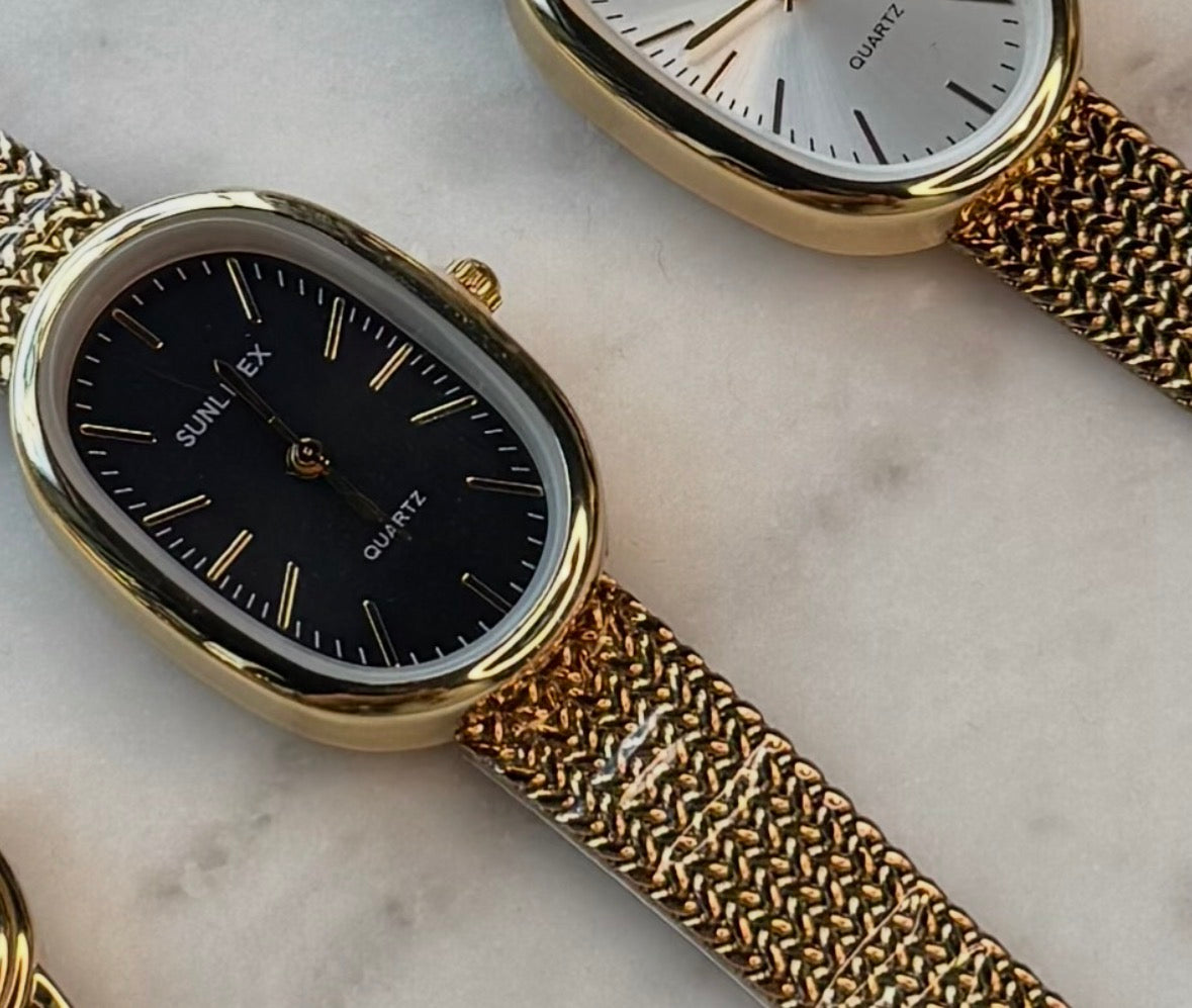 Gold watch with oval frame, mesh wristband and black face