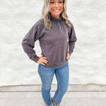 Model wearing a washed espresso colored mockneck sweatshirt with straight leg denim and faux snakeskin clogs with gold studs