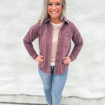 Woman wearing a washed mahogany soft button down collared soft shacket with front pocket detail on the left chest from Thread & Supply, wearing straight leg denim and brown and black mesh Mary Jane Flats